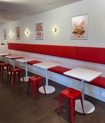 A long booth with tables and stools
AI-generated content may be incorrect.